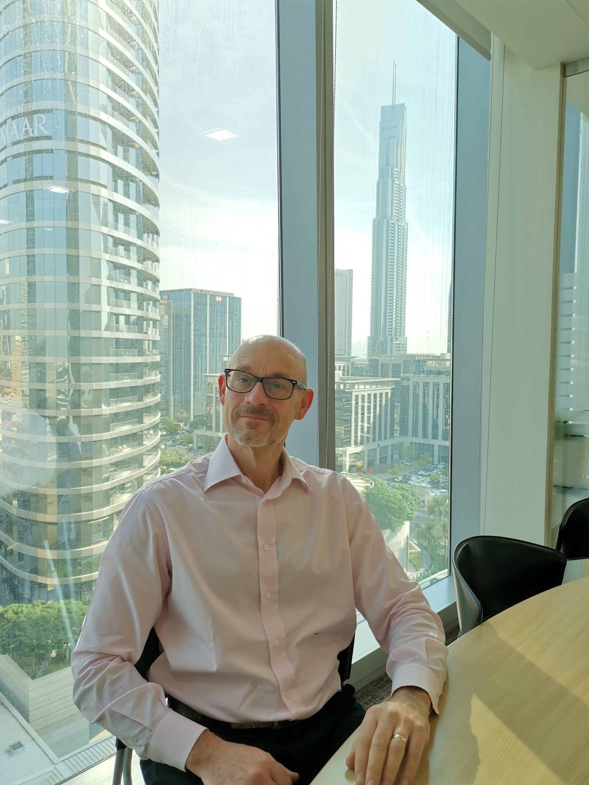 Matteo della Pietra negli uffici della Camera di Commercio Italiana negli Emirati Arabi Uniti a Dubai, con il Burj Khalifa sullo sfondo, simbolo della collaborazione con professionisti italiani e supporto alle aziende italiane negli EAU.